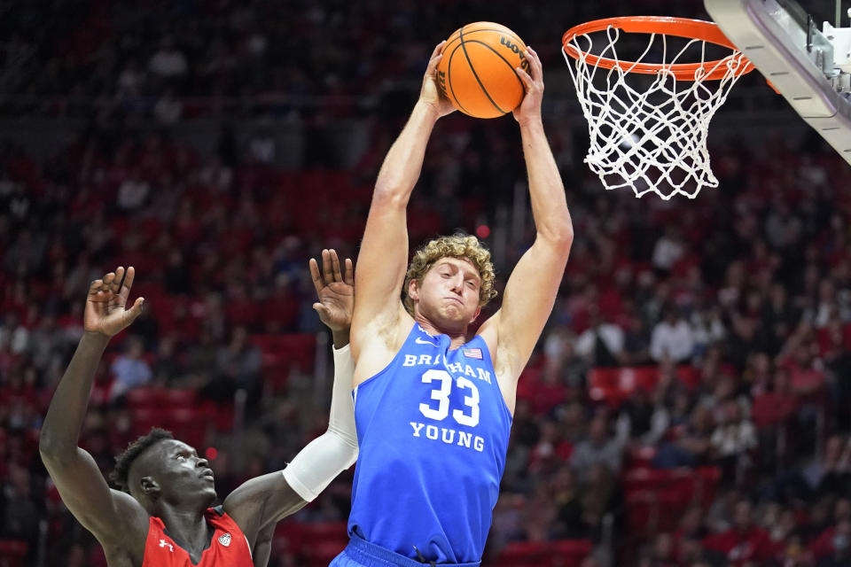 BYU forward Caleb Lohner (33) pulls down a rebound as Utah guard Both Gach, left, defends in the first half during an NCAA college basketball game Saturday, Nov. 27, 2021, in Salt Lake City. (AP Photo/Rick Bowmer)