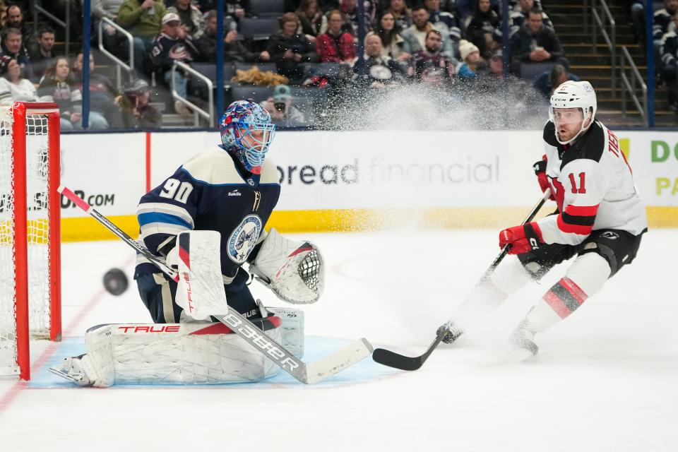 Jan 19, 2024; Columbus, Ohio, USA; Columbus Blue Jackets goaltender Elvis Merzlikins (90) turns away a shot from New Jersey Devils center Chris Tierney (11) during the second period of the NHL hockey game at Nationwide Arena.