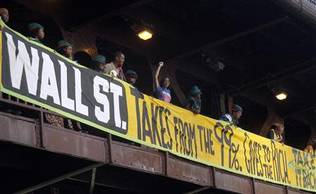 Members of a coalition called "Stand up Chicago" hang a banner from a bridge outside the Mortgage Bankers Association convention in Chicago October 10, 2011. REUTERS/Frank Polich