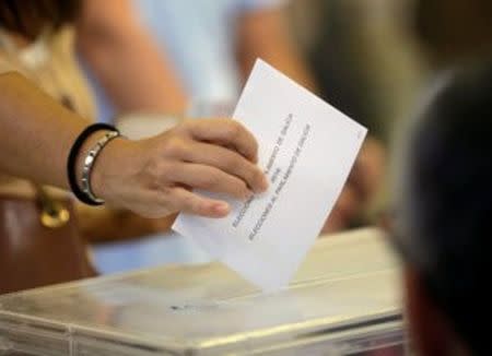 A woman casts her vote during the regional elections at a polling station in Vigo, northern Spain, September 25, 2016. REUTERS/Miguel Vidal