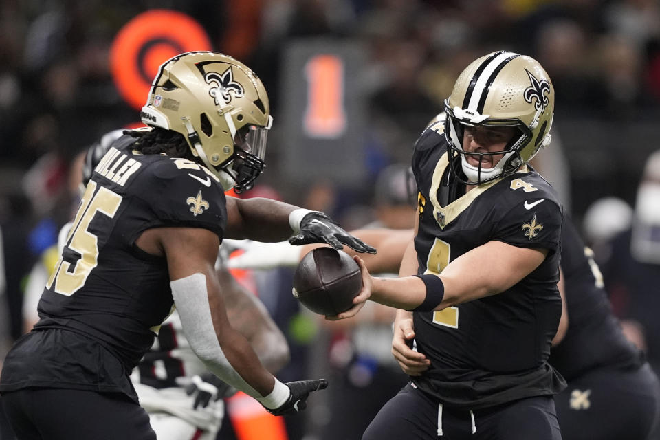 New Orleans Saints quarterback Derek Carr (4) passes to New Orleans Saints running back Kendre Miller (25) in the first half of an NFL football game against the Atlanta Falcons in New Orleans, Sunday, Jan. 7, 2024. (AP Photo/Gerald Herbert)