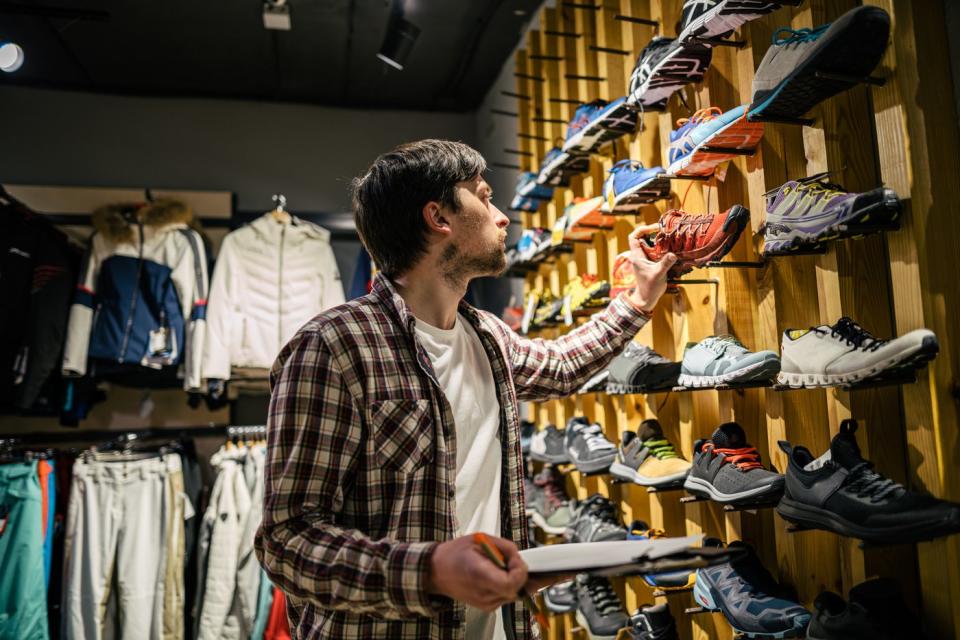 Man looks at sneakers in a store. 