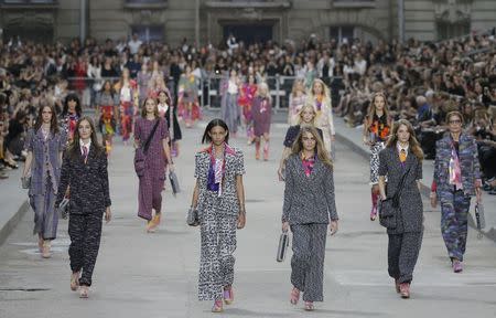 Models Josephine Le Tutour (2ndL) Binx Walton (3rdL) and Cara Delevingne (3rdR) present creations by German designer Karl Lagerfeld as part of his Spring/Summer 2015 women's ready-to-wear collection for French fashion house Chanel during Paris Fashion Week September 30, 2014. REUTERS/Gonzalo Fuentes