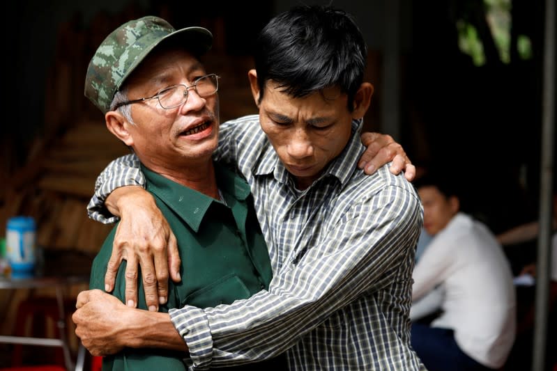 FILE PHOTO: Nguyen Dinh Gia, father of Vietnamese Joseph Nguyen Dinh Luong who is one of the suspected victims of the 39 people found dead in a refrigerated truck in Britain, is embraced by a friend at his home in Ha Tinh province, Vietnam