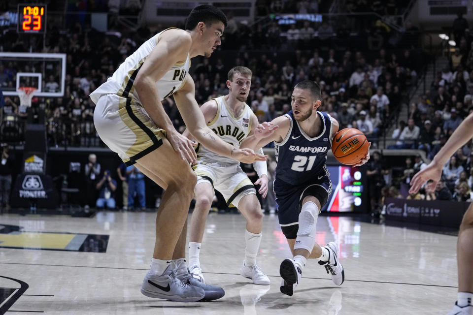 Samford guard Rylan Jones (21) drives under Purdue center Zach Edey (15) during the first half of an NCAA college basketball game in West Lafayette, Ind., Monday, Nov. 6, 2023. (AP Photo/Michael Conroy)