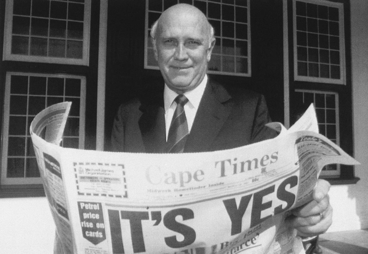 FILE — South African President F.W. de Klerk poses outside his office in Cape Town, South Africa March 18, 1992, while displaying a copy of a local newspaper with banner headlines declaring a "Yes" result in a referendum vote to end apartheid and share power with the black majority for the first time. De Klerk, who shared the Nobel Peace Prize with Nelson Mandela and as South Africa's last apartheid president oversaw the end of the country's white minority rule, died at the age of 85, on Nov, 11, 2021. (AP. Photo, File)