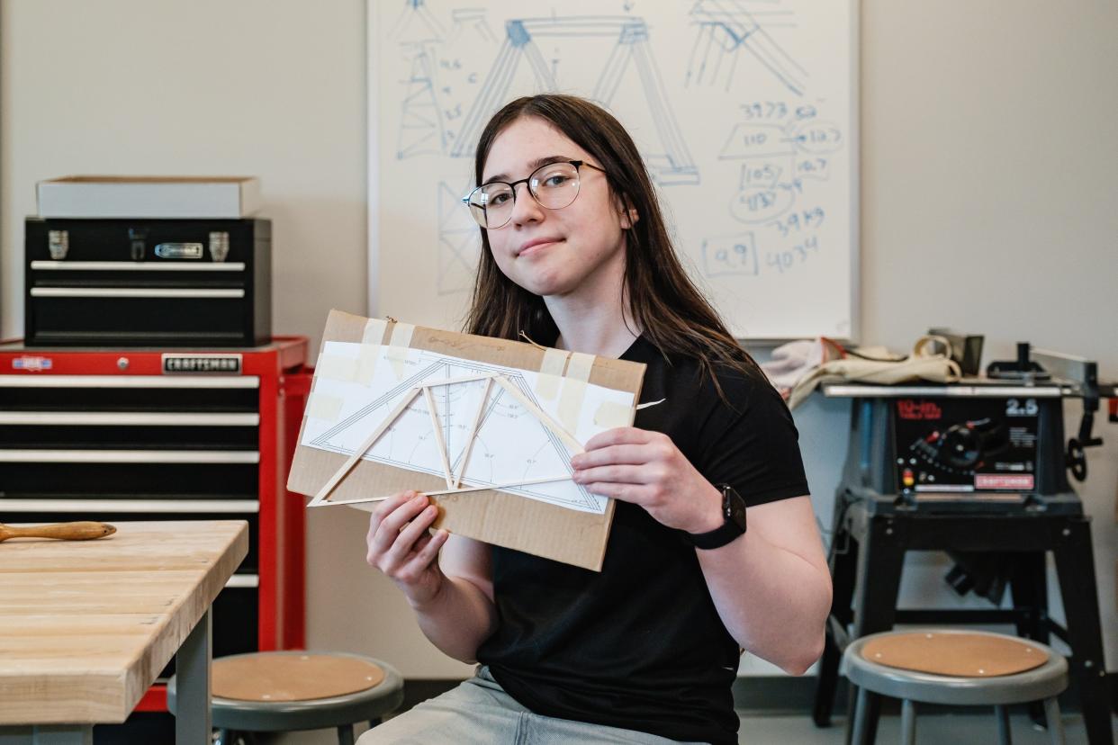 Dover High School junior Trinity Dreher holds up part of a scaled-down model bridge at Dover High School. Dreher and classmate Brady Miller will compete in this year's International Bridge Building Competition at Kent State University Tuscarawas.