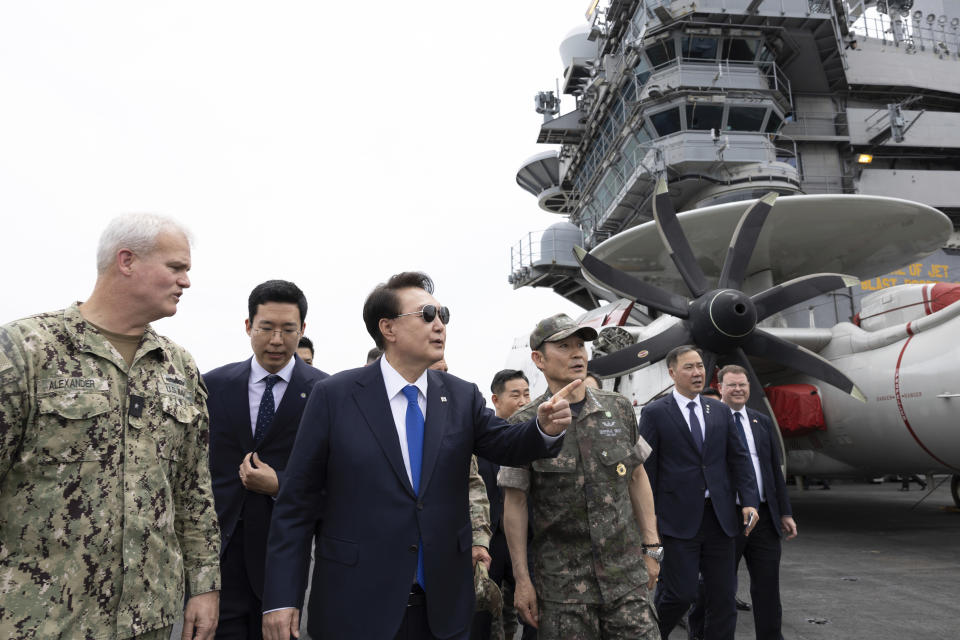 South Korean President Yoon Suk Yeol, third from left, boards the USS Theodore Roosevelt aircraft carrier at the South Korean naval base in Busan, South Korea, Tuesday, June 25, 2024 (South Korean Presidential Office/Yonhap via AP)