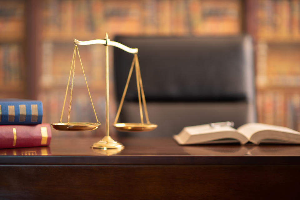 justice scales and law books on desk in lawyer office.