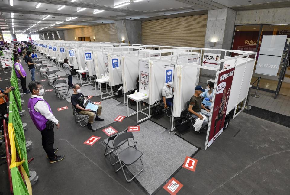 People receive the Pfizer COVID-19 vaccine at the Noevir Stadium Kobe in Kobe, western Japan, Monday, May 31, 2021. The stadium is being used as an inoculation venue for local residents over 65 years old. Japan, seriously behind in coronavirus vaccination efforts, is scrambling to boost daily shots as the start of the Olympics in July closes in. (Yu Nakajima/Kyodo News via AP)