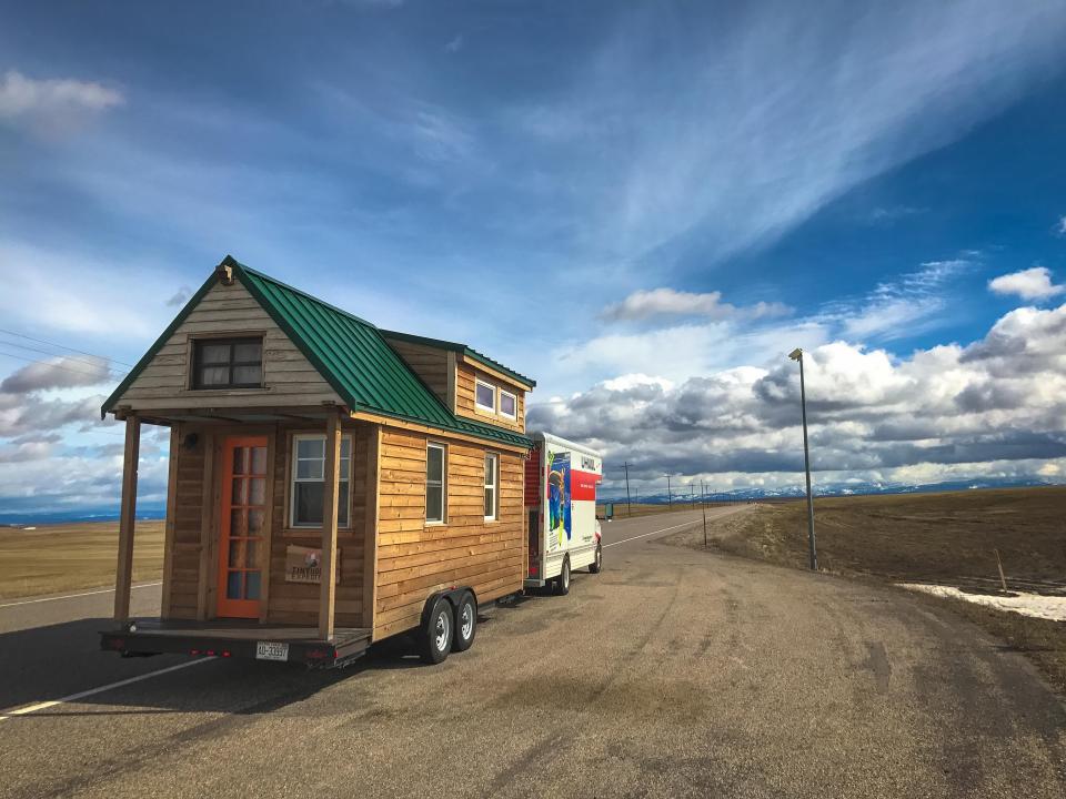 Christian Parsons and Alexis Stephens' tiny house driving down the road with a uhaul attached