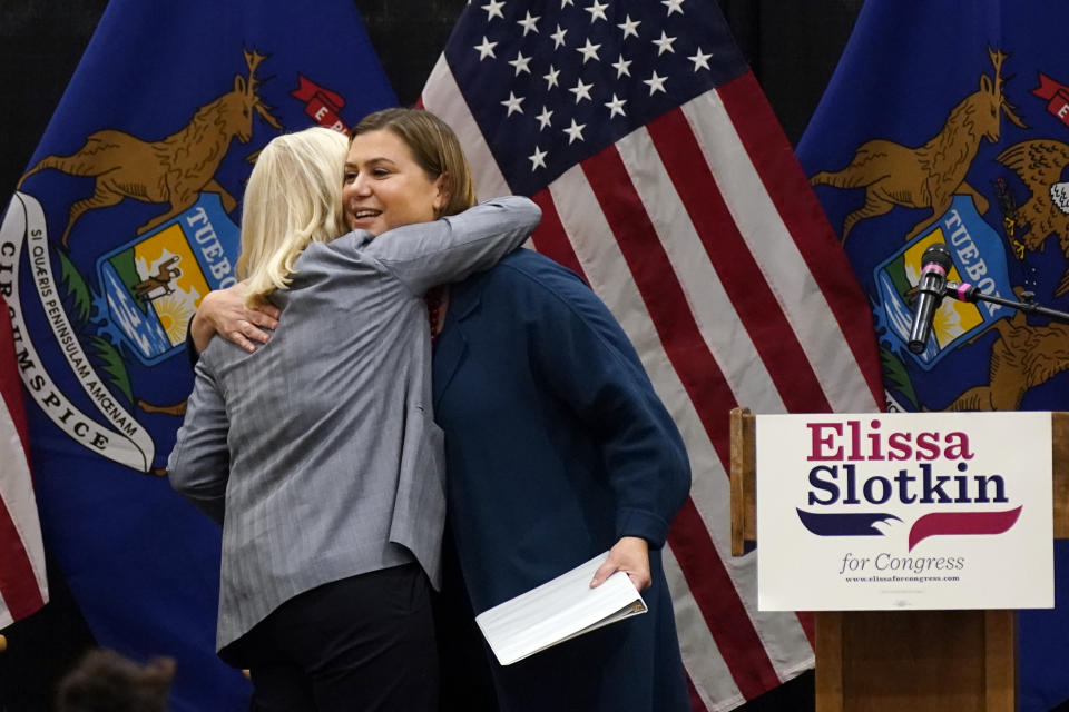 U.S. Rep. Elissa Slotkin, D-Mich., right, hugs Rep. Liz Cheney, R-Wyo., during a campaign rally, Tuesday, Nov. 1, 2022, in East Lansing, Mich. Slotkin emphasized how a shared concern for a functioning democracy can unite Democrats and Republicans despite policy disagreements. (AP Photo/Carlos Osorio)