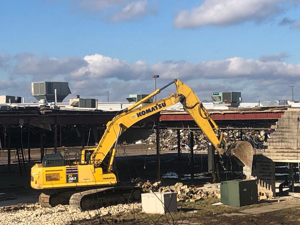 An excavator tears down a wall Thursday at the former Carnation City Mall in Alliance.