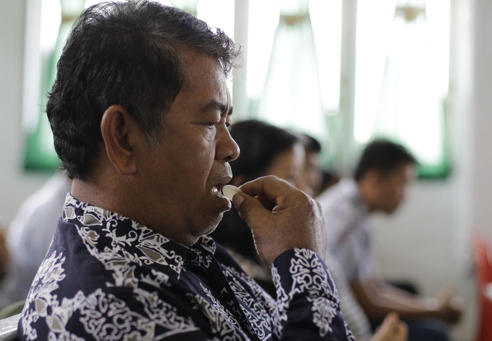 A Christian receives communion inside a church at the earthquake and tsunami-hit town of Palu, Central Sulawesi, Indonesia Sunday, Oct. 7, 2018. Christians dressed in their tidiest clothes flocked to Sunday sermons in the earthquake and tsunami damaged Indonesian city of Palu, hoping for answers to the double tragedy that inflicted deep trauma on their community. (AP Photo/Aaron Favila)