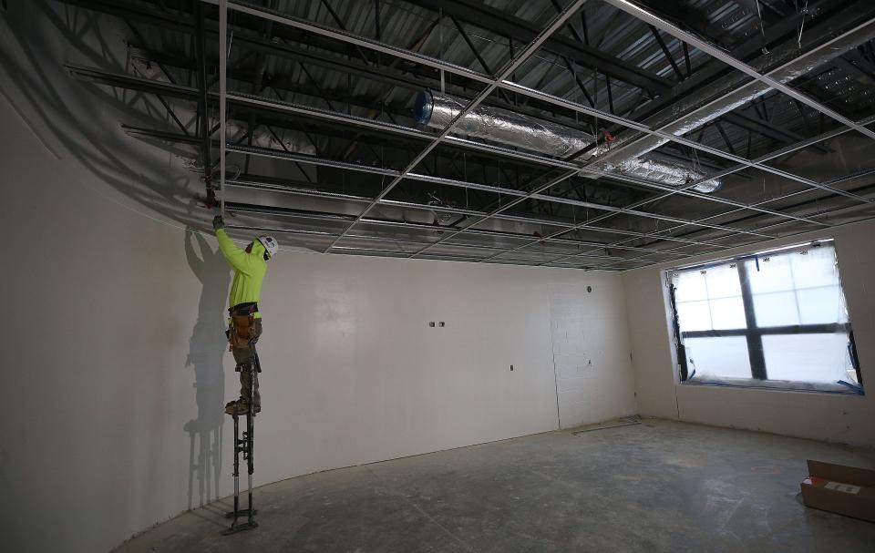 Walter Gomez, with OKI, hangs a ceiling grid at Westerville's new Minerva Park Middle School on Dec. 15.