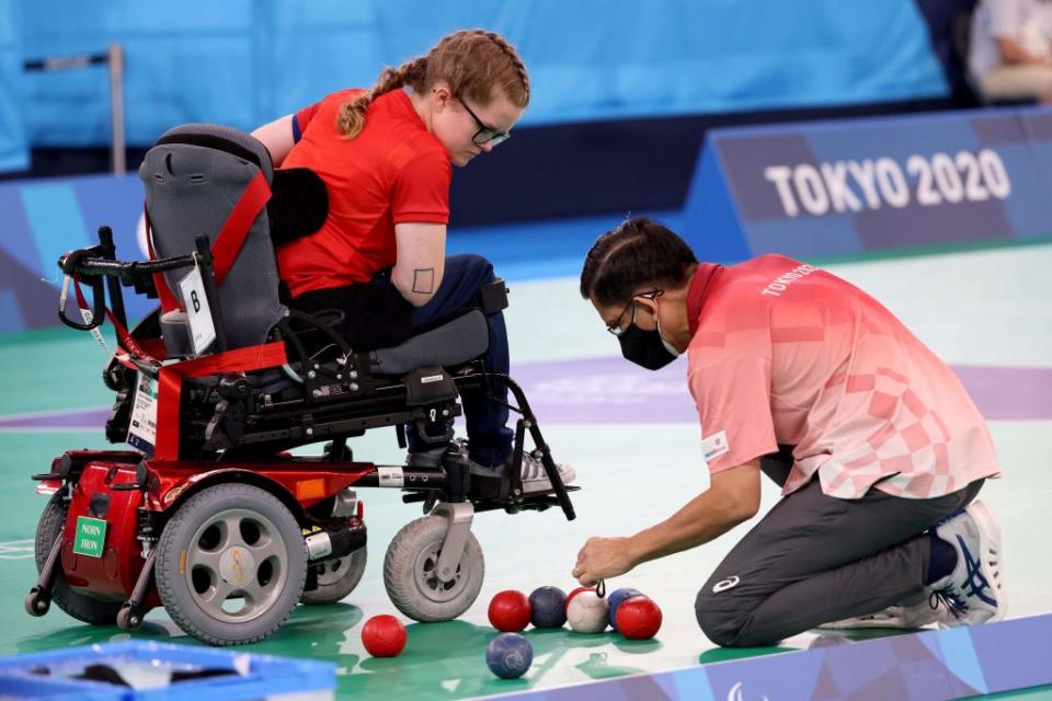 Mujer en silla de ruedas jugando boccia.