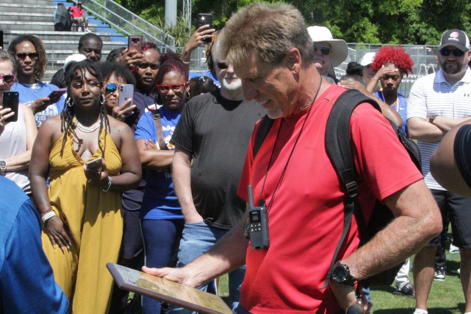 Pine Forest track and field head coach Paul Bryan looks at the plaque presented to him at the Escambia County Championship meet on Saturday, April 13, 2024, at Booker T. Washington High School.