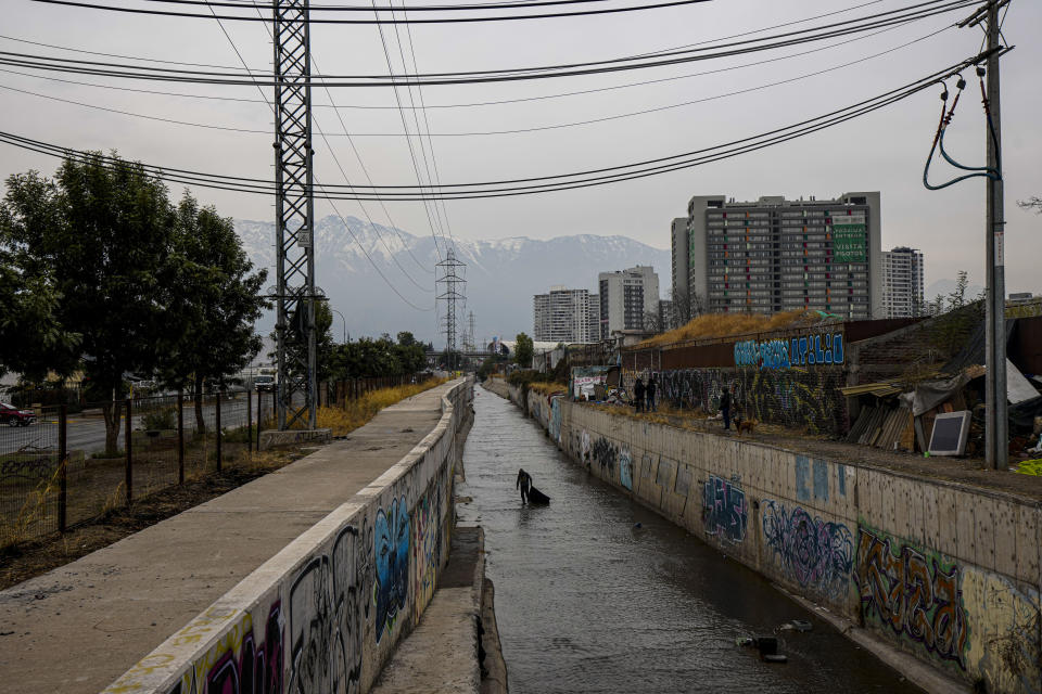 A homeless Chilean man who gave his name as Jose collects items, such as metal, from the El Zanjón de la Aguada water canal, in hopes of reselling it in Santiago, Chile, Wednesday, May 15, 2024. Over the last four years, the rate of homelessness in one of South America's richest economies has jumped more than 30%. (AP Photo/Esteban Felix)