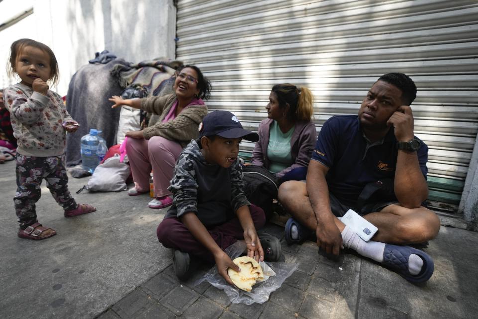 A migrant family from Venezuela eats breakfast alongside the railroad tracks in Mexico City, Tuesday, March 26, 2024. (AP Photo/Fernando Llano)