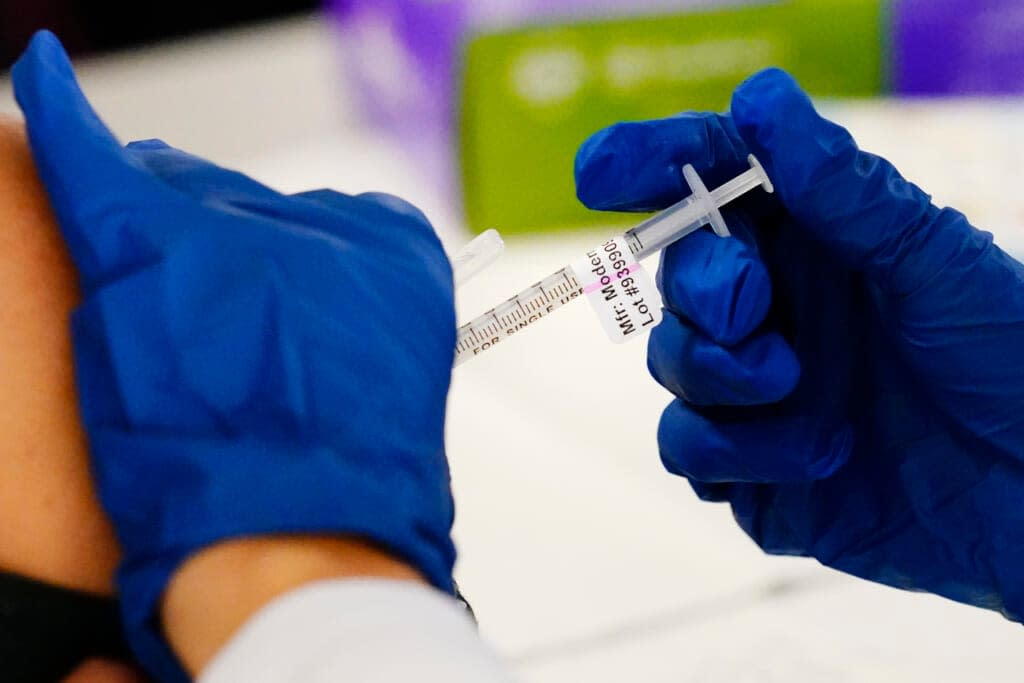 FILE – A health worker administers a dose of a Moderna COVID-19 vaccine during a vaccination clinic in Norristown, Pa., Tuesday, Dec. 7, 2021. Moderna on Thursday, April 28, 2022, asked U.S. regulators to authorize low doses of its COVID-19 vaccine for children younger than 6, a long-awaited move toward potentially opening shots for millions of tots by summer.(AP Photo/Matt Rourke, File)