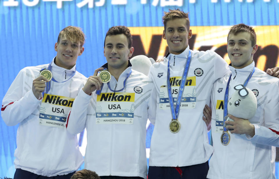 Gold medalist USA team display their medals after breaking the world record at the men's 4x100 freestyle relay at the 14th FINA World Swimming Championships in Hangzhou, China on Tuesday Dec. 11, 2018. USA team set a new world record with a time of 3:03.03. (AP Photo/Ng Han Guan)