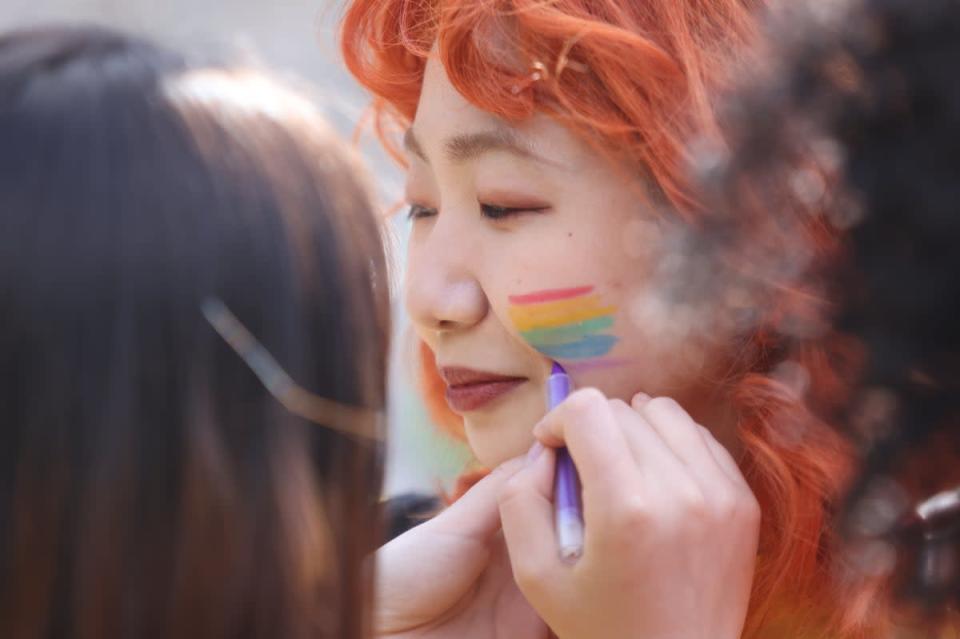 Pride volunteers paint each other’s faces (James Manning/PA) (PA Wire)