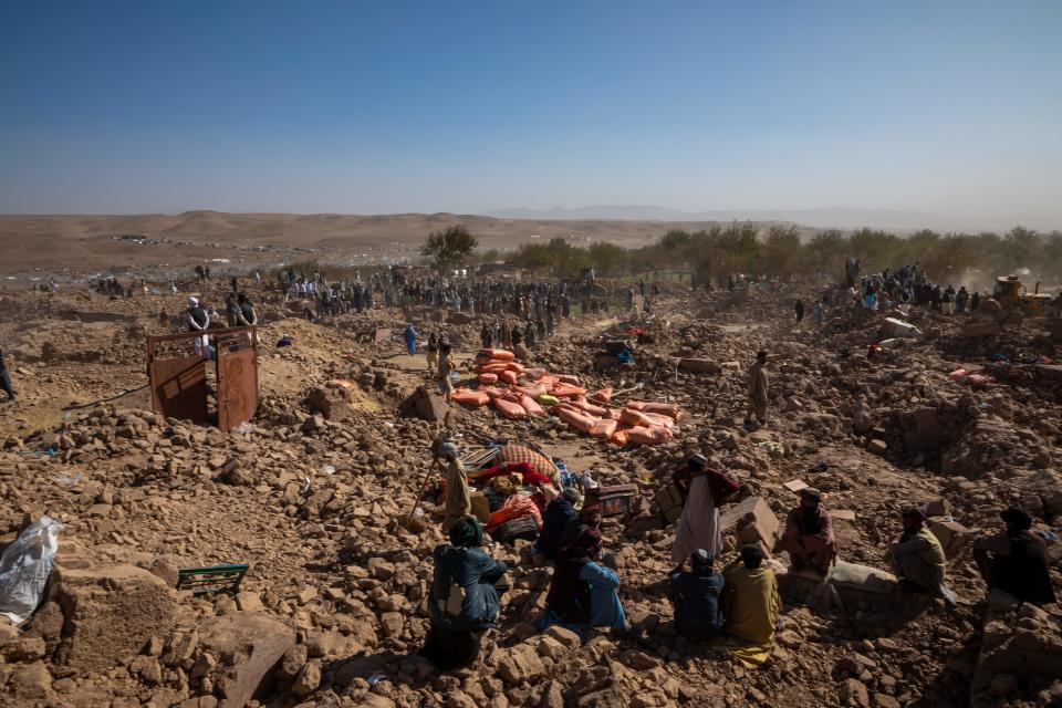 Afghans excavate the ruins of demolished buildings to recover bodies.