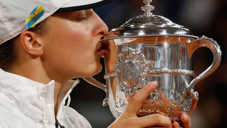 Świątek kisses the trophy after winning the 2022 French Open. - Yves Herman/Reuters