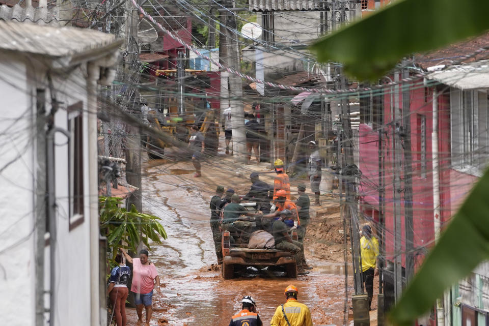 Rescue workers and volunteers transport the body of a landslide victim near Barra do Sahi beach after heavy rains in the coastal city of Sao Sebastiao, Brazil, Wednesday, Feb. 22, 2023. (AP Photo/Andre Penner)