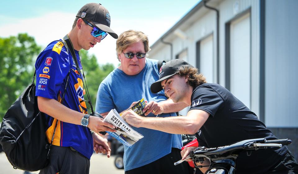 Driver Colton Herta signs an autograph for Jared Freier of Hilbert on IndyCar race weekend last year. The paddock for IndyCar is open to all spectators, but NASCAR restricts access tightly.