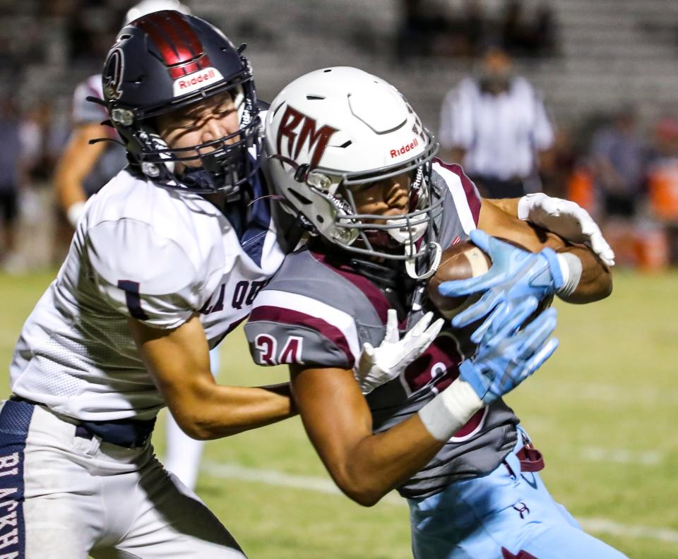 Rancho Mirage's Erik Beltran (34) pulls in a pass intended for La Quinta's Juan Bautista (1) for an interception during the first quarter of their game in Rancho Mirage, Calif., Friday, Oct. 20, 2023.