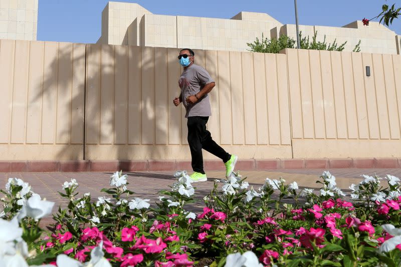 A man wears a protective face mask while jogging, following the outbreak of the coronavirus disease (COVID-19), in Riyadh