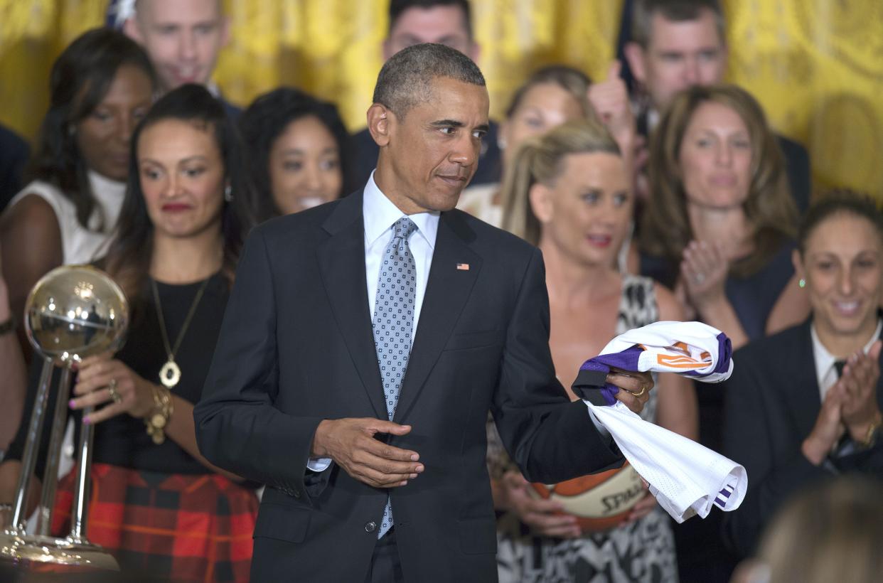 US President Barack Obama  holds a jersey given to him during an event congratulating the 2014 WNBA champions Phoenix Mercury at the White House in Washington, DC, August 26, 2015.        AFP PHOTO/JIM WATSON        (Photo credit should read JIM WATSON/AFP/Getty Images)