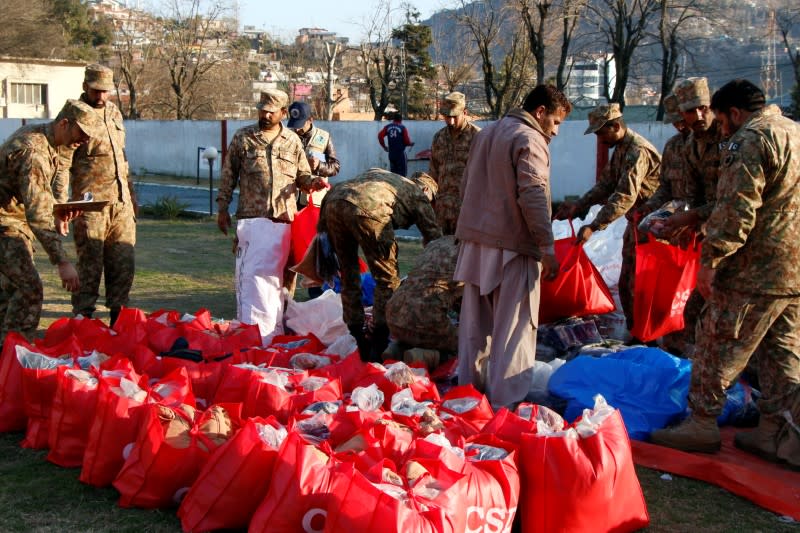 Pakistan Army soldiers pack relief goods to distribute among people in affected areas after heavy snowfall and avalanches, in Muzaffarabad,