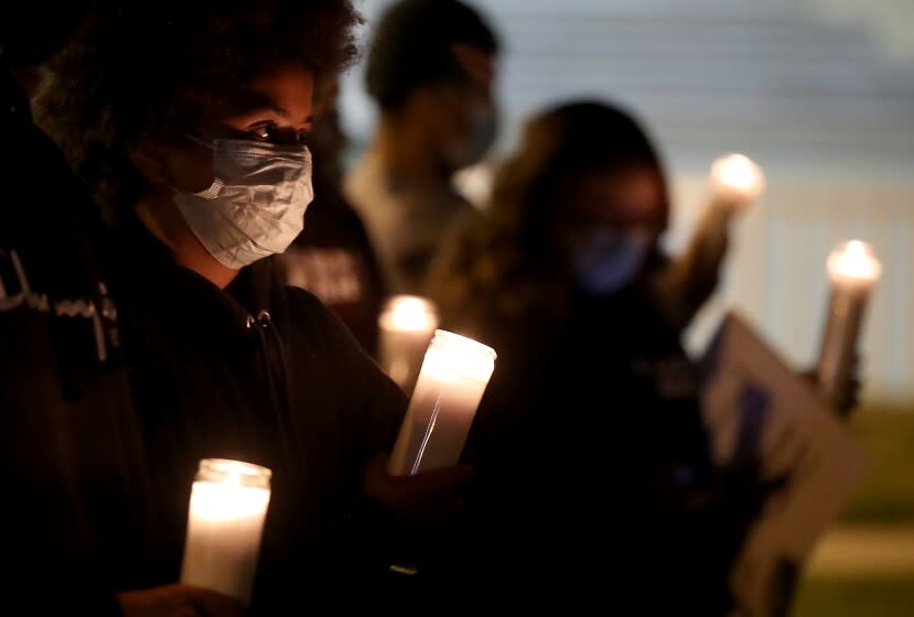 PASADENA, CALIF. - NOV. 22, 2021. Residents of the Villa Parke neighborhood of Pasadena gather for a candlelight vigil for shooting victim Iran Moreno-Balvaneda on Monday night, Nov. 22, 2021. Iran, 13, was killed by a stray bullet as he played video games inside his home. Authorities are investiogating the shooting, one of many in Villa Parke in recent months. ( Luis Sinco / Los Angeles Times)