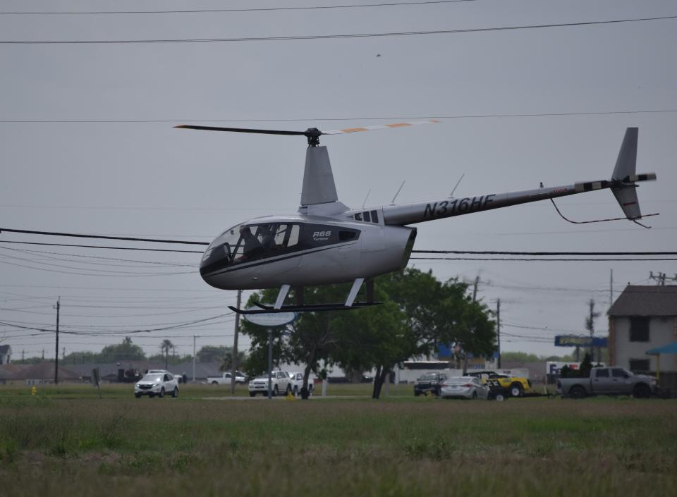 A helicopter hovers above an open field near the Oso Bay Wetlands Preserve during an investigative search on Monday.