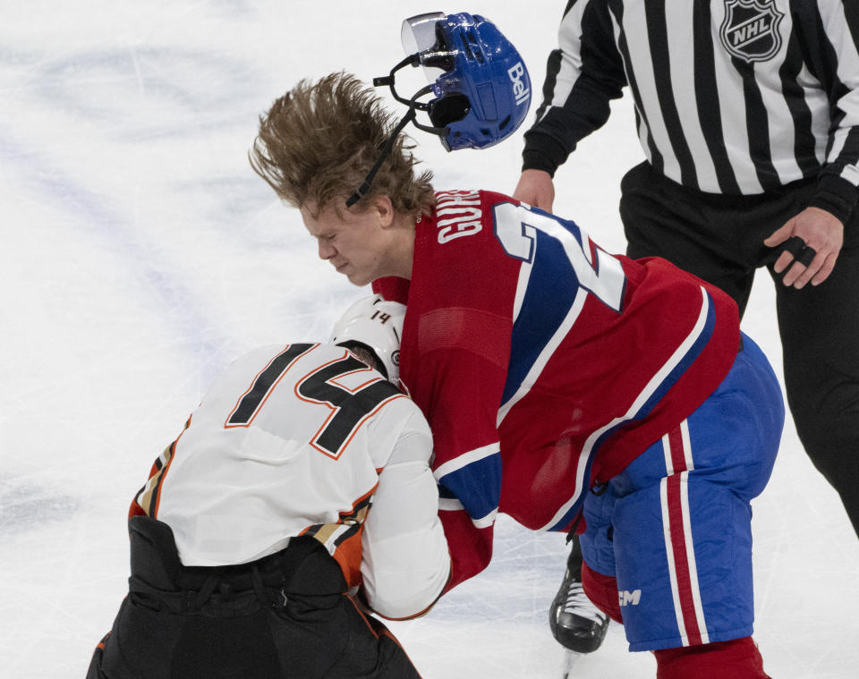 Montreal Canadiens' Kaiden Guhle (21) and Anaheim Ducks' Adam Henrique (14) fight during the third period of an NHL hockey game Tuesday, Feb. 13, 2024, in Montreal. (Christinne Muschi/The Canadian Press via AP)