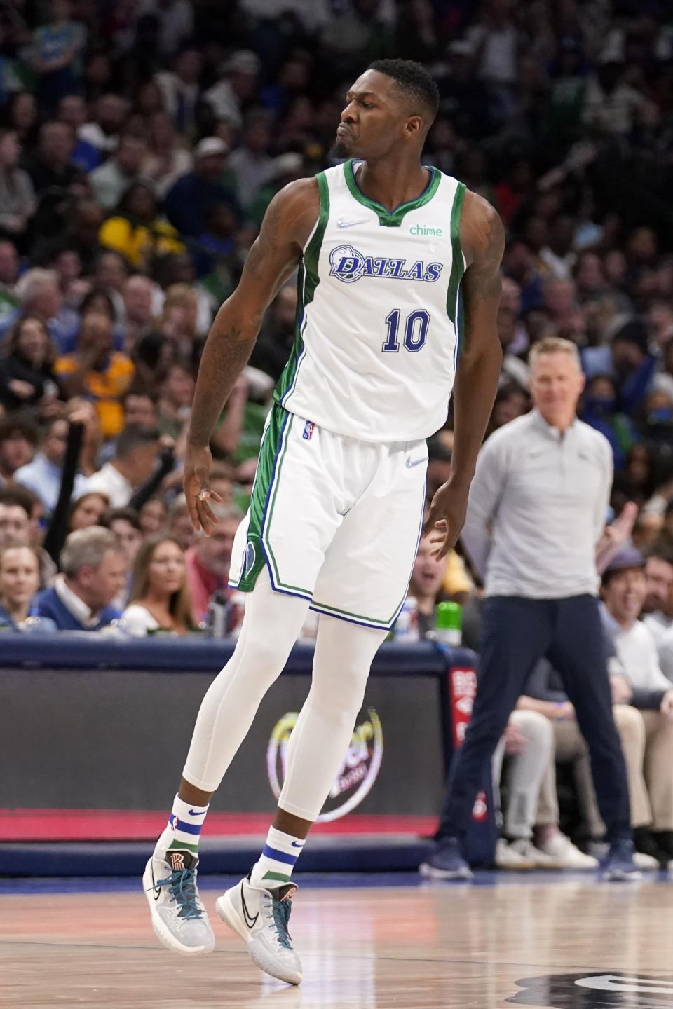 Dallas Mavericks forward Dorian Finney-Smith celebrates after sinking a three-point basket in the first half of an NBA basketball game against the Golden State Warriors in Dallas, Thursday, March, 3, 2022. (AP Photo/Tony Gutierrez)