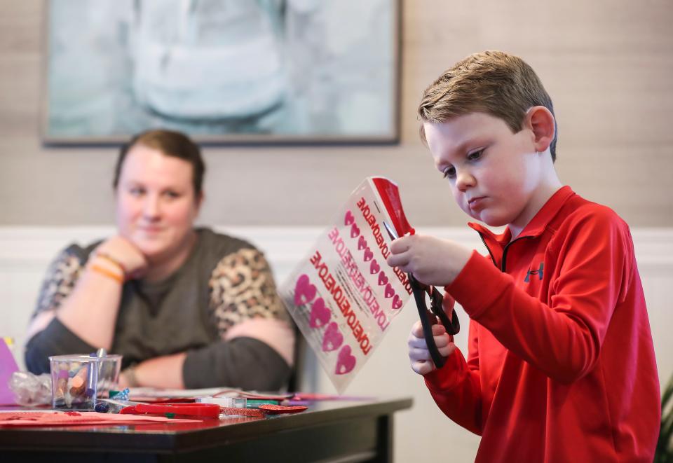 Beckham Goodale works on some Valentine's Day cards at his Charlestown, Ind. home as mother Erin Goodale watches. The 7-year-old has leukemia and earned the nickname Candy Man after always giving candy to his doctors and nurses on his regular visits at Norton Children's Cancer Institute. He loves to see people smile, regardless how he may be feeling that day. Feb. 9, 2022