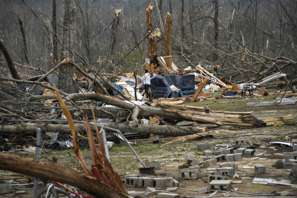 Brittney Downs looks through the debris of a family member's destroyed home the day after a deadly tornado ravaged the area, in Beauregard, Ala., March 4, 2019. (Photo: Julie Bennett/AP)