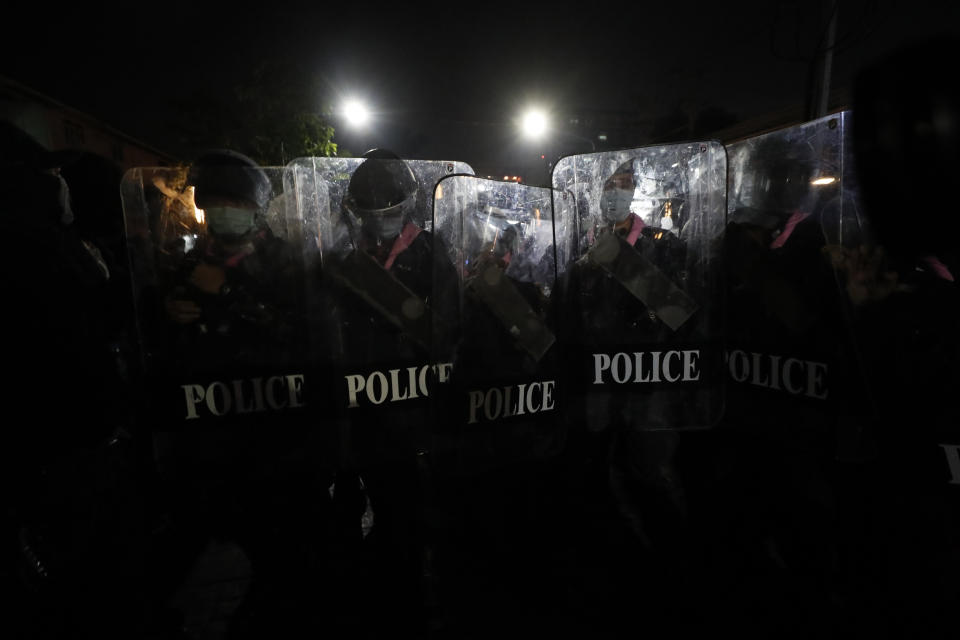 Police hold shields in tight formation as pro-democracy protesters march demanding the release of pro-democracy activists in Bangkok, Thailand, Wednesday, Feb. 10, 2021. Protesters demanded the government to step down, the constitution to be amended to make it more democratic and the monarchy be more accountable. (AP Photo/Sakchai Lalit)