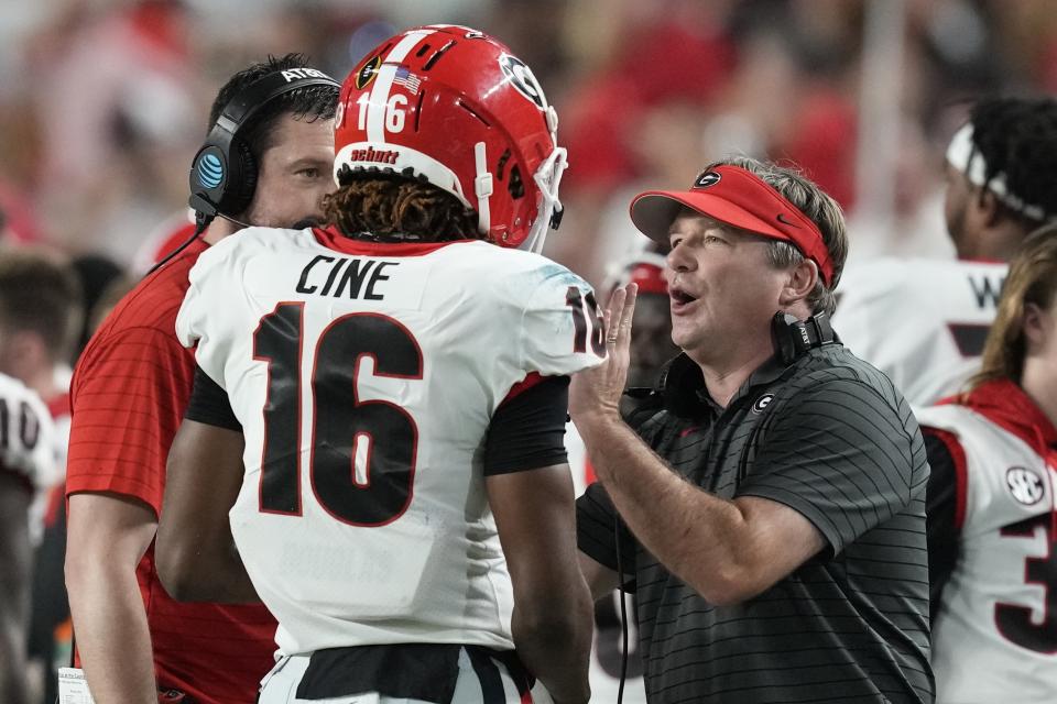 Georgia head coach Kirby Smart talks with defensive back Lewis Cine during the first half of the Orange Bowl NCAA College Football Playoff semifinal game against Michigan, Friday, Dec. 31, 2021, in Miami Gardens, Fla. (AP Photo/Rebecca Blackwell)