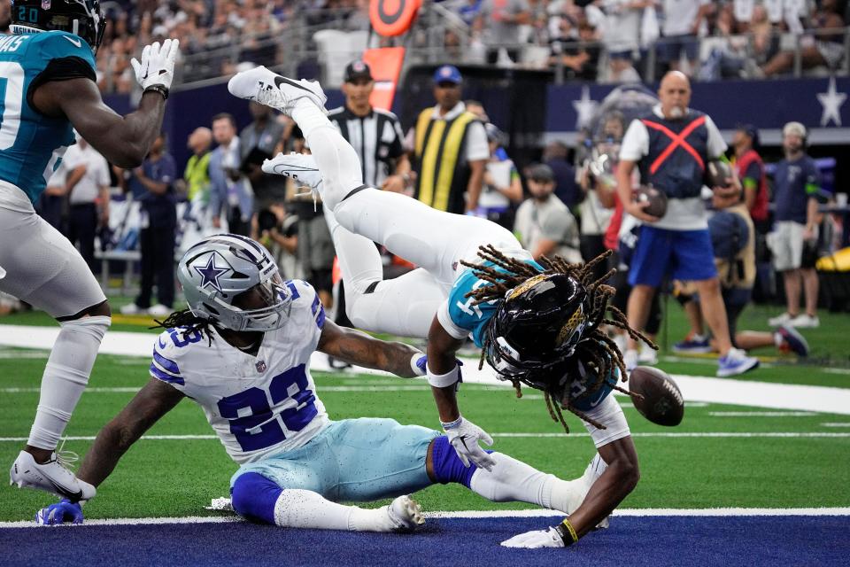 Dallas Cowboys running back Rico Dowdle (23) fumbles the ball after a strip by Jacksonville Jaguars cornerback Gregory Junior (34) during the first half of an NFL preseason football game, Saturday, Aug. 12, 2023, in Arlington, Texas. (AP Photo/Sam Hodde)