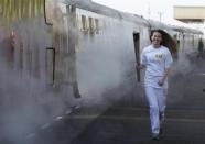 Helana Scott runs with the Olympic torch before boarding a train during the London 2012 Olympic Games Torch Relay rehearsal at Great Central Railway in Leicester, central England April 20, 2012.