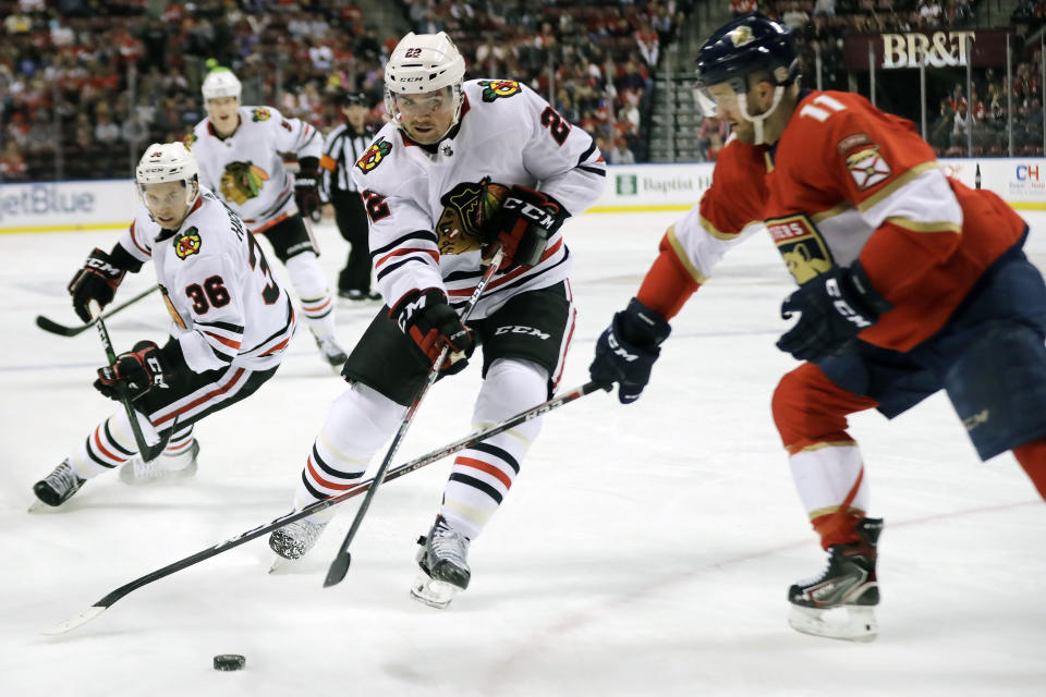 Chicago Blackhawks center Ryan Carpenter (22) skates with the puck against Florida Panthers left wing Jonathan Huberdeau (11) during the first period of an NHL hockey game, Saturday, Feb. 29, 2020, in Sunrise, Fla. (AP Photo/Brynn Anderson)