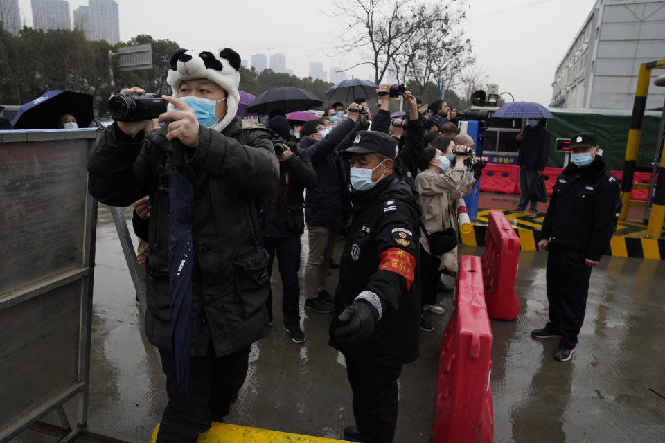 Security personnel block journalists after the World Health Organization team arrive at the Baishazhou wholesale market on the third day of field visit in Wuhan in central China's Hubei province on Sunday, Jan. 31, 2021. (AP Photo/Ng Han Guan)