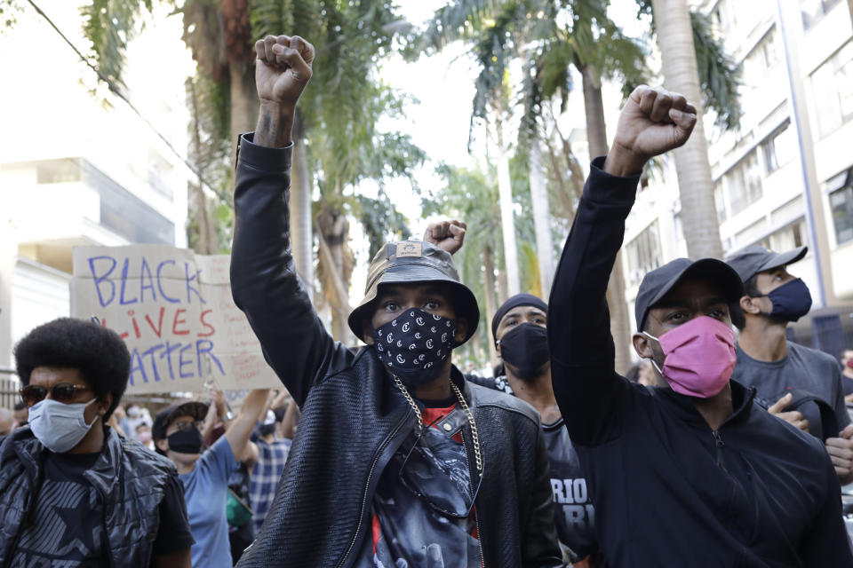 People protest against crimes committed by the police against black people in the favelas, outside the Rio de Janeiro's state government, Brazil, Sunday, May 31, 2020. The protest, called "Black lives matter," was interrupted when police used tear gas to disperse people. "I can't breathe", said some of the demonstrators, alluding to the George Floyd's death. (AP Photo/Silvia Izquierdo)