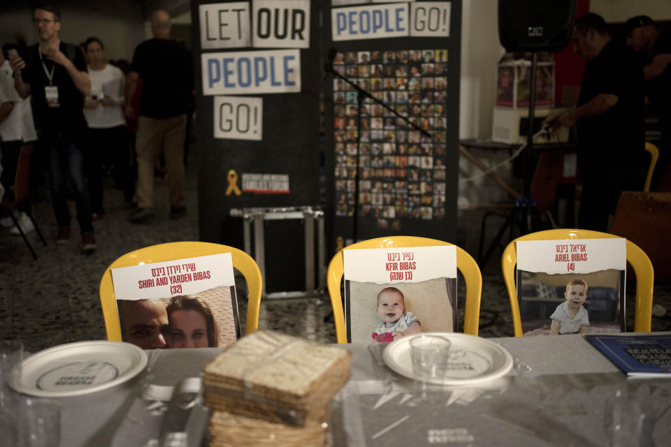 Chairs for the Bibas family, hostages held in Gaza at a Passover seder table set on Thursday, April 11, 2024, at the communal dining hall at Kibbutz Nir Oz in southern Israel, where a quarter of all residents were killed or captured by Hamas on Oct. 7, 2023. (AP Photo/Maya Alleruzzo)