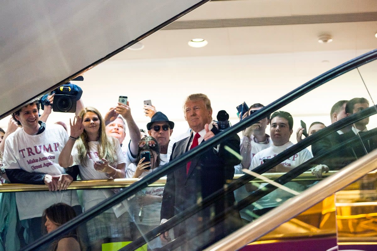 Donald Trump rides down a golden escalator in his New York skyscraper to a press event announcing his candidacy for the presidency on 16 June 2015 (Getty)