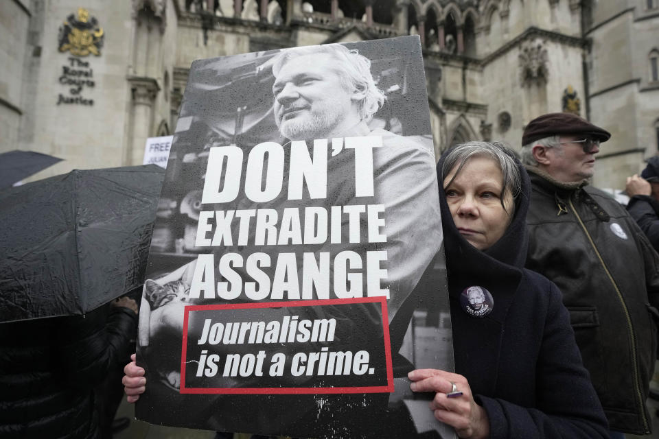 FILE - A protester holds a placard outside the Royal Courts of Justice in London, Wednesday, Feb. 21, 2024. A London court is due to rule whether WikiLeaks founder Julian Assange can challenge extradition to the United States on espionage charges. Two judges will issue a ruling Tuesday morning in the High Court on whether Assange can make one final appeal in England. (AP Photo/Kin Cheung, File)